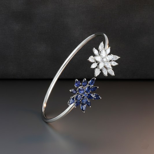 Silver bracelet with diamond and sapphire flower-shaped clasps on a dark background